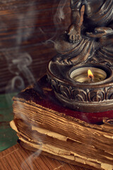 Spiritual still life of bronze Buddha statue and smoke of aroma sticks, Relaxation, meditation.