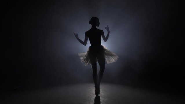 Ballerina. White background. in the dark with light and smoke on the background, slow motion.