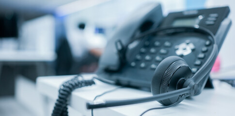 close up soft focus on headset with telephone devices at office desk for customer service support...