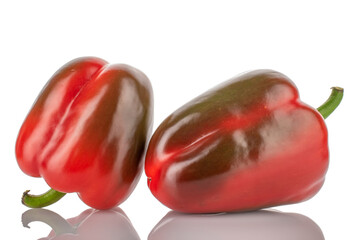 Two red organic, bell peppers, close-up, on a wooden table.