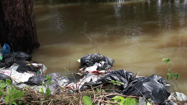 Chaiyaphum, Thailand - 8 October 2022 : A large amount of plastic waste lies along the river during high flooding.