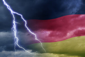 Dramatic stormy clouds with lightning next to German flag . Upcoming crisis and economy problems in...