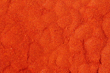 dry organic kashmiri red chili pepper powder texture background selective focus,well known for dark red color food recepi in indian gujarati food    