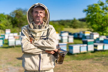 Apiarist in protective beekeeping suit. Portrait of handsome beekeeper.