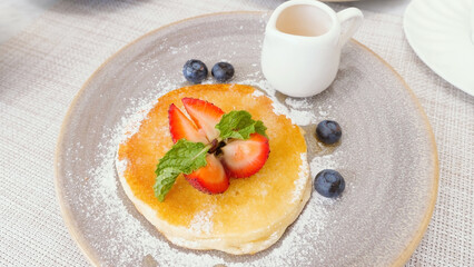 Pouring maple syrup on stack of delicious buttermilk pancakes. Real time footage, tasty food