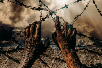 Jail break. Hands holding on to barbed wire on the wall of the prison. Law. freedom