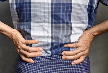 Asian elder man suffering from back and loin pain. It can be caused by renal stone.