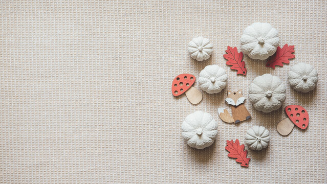 Autumn creative craft background web banner with decorative clay pumpkins and wooden autumn leaves. Decorative pumpkins flat lay on natural fabric background