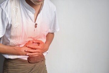 Asian man suffering from upper abdominal pain. It can be caused by stomach ache, enteritis,...