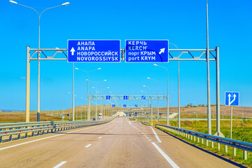 Tavrida highway. Metal structures with information road signs direction to the side cities. Translation from Russian on boards:  Anapa, Novorossiysk, Kerch, port Krym (Crimea). - obrazy, fototapety, plakaty