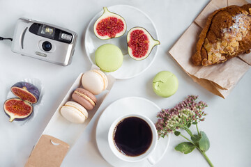 aesthetic film camera flatlay, cups of coffee, figs and macarons on a white background, top view