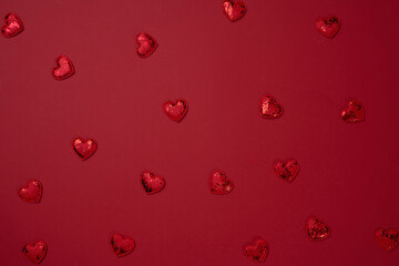 Red textile heart on red paper background