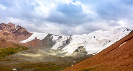 Beautiful nature of rocky mountains and peaks with glaciers. Unusual landscape of nature. Rocks on the background of the sky with clouds. Bad weather cyclone, rainy season, foggy day.