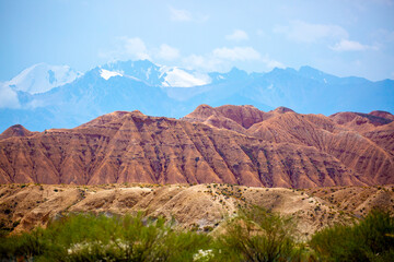 Natural unusual landscape of red rocks against the backdrop of blue mountains. The extraordinary beauty of nature is similar to the Martian landscape. Amazingly beautiful landscape.