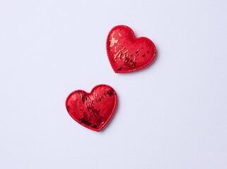 Fototapeta premium Red textile heart on a white paper background, top view.