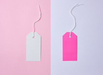 Empty white and pink cardboard tag on a white rope, pink background. Price tag template