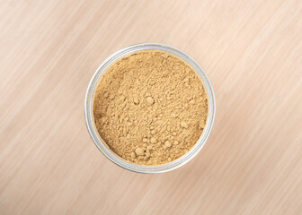 Top view of an open jar of ground ginger root powder.