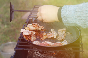 natural light. barbecue. a frying pan is used for cooking. fire. firewood. Picnic