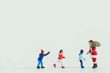 Children stand in a row in front of Santa Claus isolated on white background