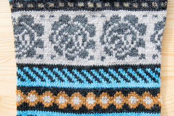 Knitted sweate, fragment. Handmade fabric. Knitted fabric consists of various ornaments.