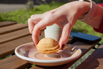 A woman's hand holds a nut with condensed milk.