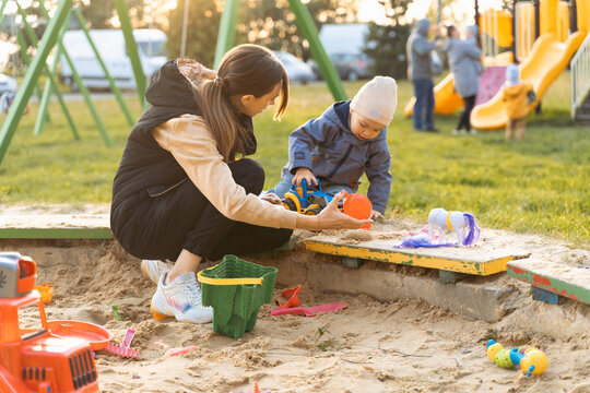 Mother and son playing in sandbox. Little builder. Education, and imagination, purposefulness concept. Support childhood parenthood symbol