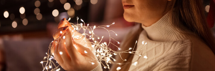 beautiful young candid woman holding in hands near face bright led garland of glowing lights and...