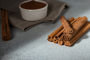 Ceylon cinnamon sticks and ground cinnamon bowl on linen napkin