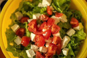 homemade light salad of lettuce, tomatoes, feta cheese and canned salmon. home cooking.