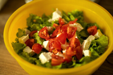 homemade light salad of lettuce, tomatoes, feta cheese and canned salmon. home cooking.