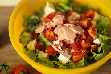 homemade light salad of lettuce, tomatoes, feta cheese and canned salmon. home cooking.
