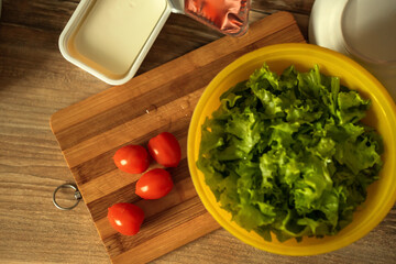 homemade light salad of lettuce, tomatoes, feta cheese and canned salmon. home cooking.