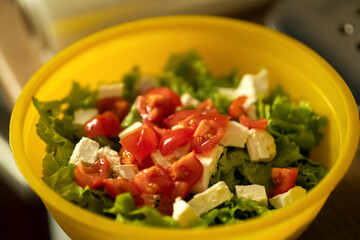 homemade light salad of lettuce, tomatoes, feta cheese and canned salmon. home cooking.