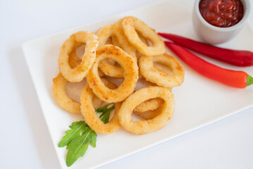 fast food breaded onion rings fried with sauce on a plate
