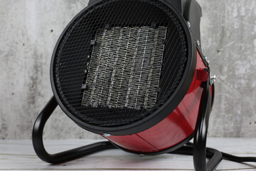 Heater for the apartment, closeup. Electric halogen fan heater on floor. Heat gun with a fan for...