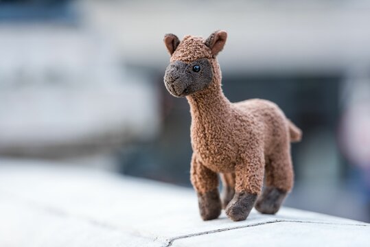 Closeup Of A Cute Brown Alpaca Toy On A Concrete Balustrade