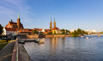 Naklejka premium Panoramic view of Ostrow Tumski Island with Holy Cross collegiate and St. John Baptist gothic cathedral over Odra river in historic old town quarter of Wroclaw in Poland