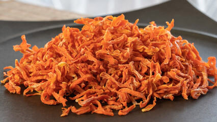 黒い皿に盛られた備蓄できる乾燥野菜（人参）