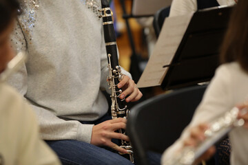 Female pupil playing clarinet concert in school orchestra musical instrument close-up