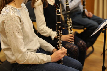 A student girl with a clarinet in her hand at a lesson in the school orchestra