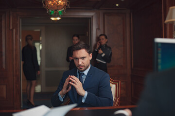 Handsome businessman wearing suit in Hotel check in at reception or front office being 