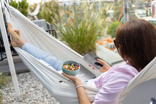 woman with laptop in hammock eating chia pudding