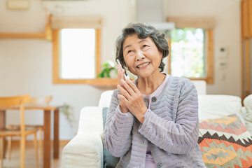 自宅で電話をするシニア女性