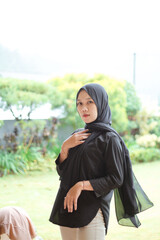 Asian young woman who wants to express something with expression. Asian female model wearing black t-shirt on bokeh background.