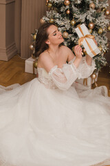 Beautiful woman in evening dress near the Christmas tree