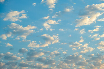 Blue sky with twilight clouds. The sun is setting over the horizon. Yellow dawn. Red sunset. Pink clouds.