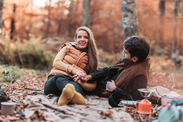 Romantic couple having a picnic in the woods. Autumn vibes