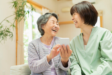Fototapeta premium 孫にスマートフォンの使い方を教わるシニア女性