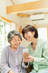 Fototapeta premium 孫にスマートフォンの使い方を教わるシニア女性
