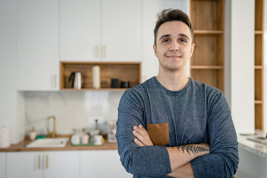 Front View Portrait Of One Man Young Adult Caucasian Male Standing In The Kitchen In Day At Home Happy Smile Confident Copy Space Waist Up Real People